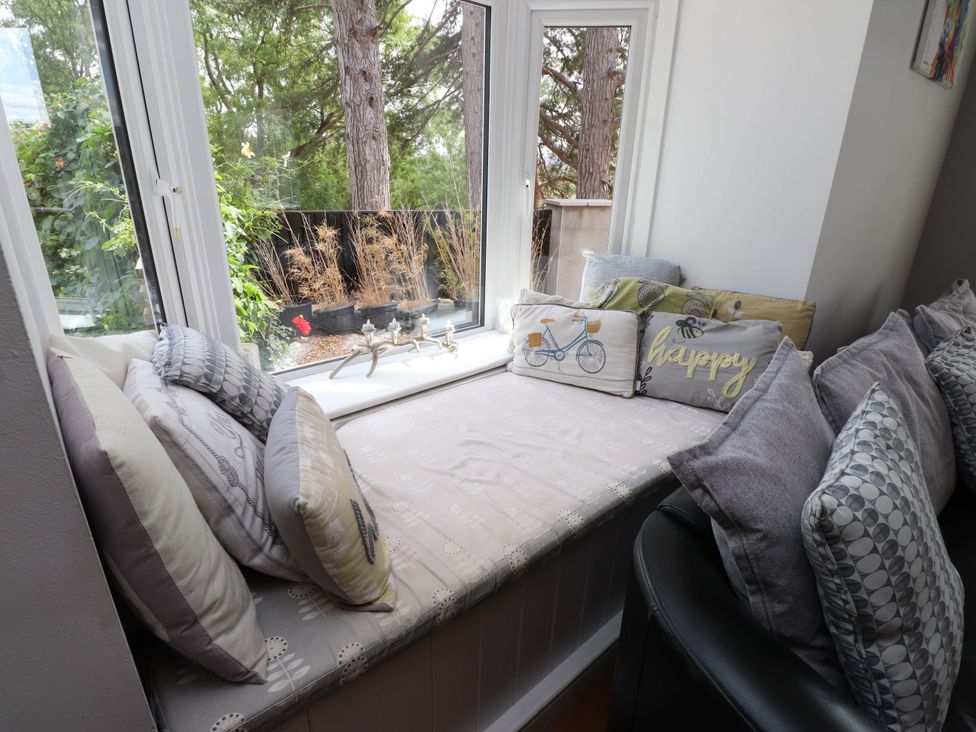 A window seat with cushions and potted plants at Tyddyn Elidir near Old Colwyn