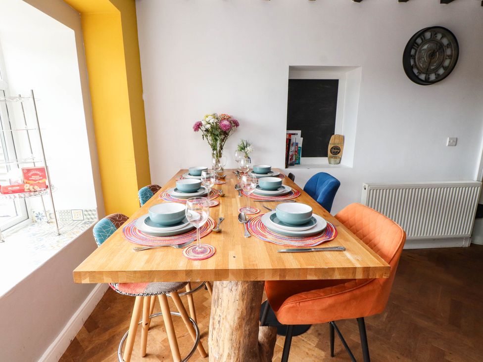 A dining table set with dishes and chairs at Tyddyn Elidir near Old Colwyn