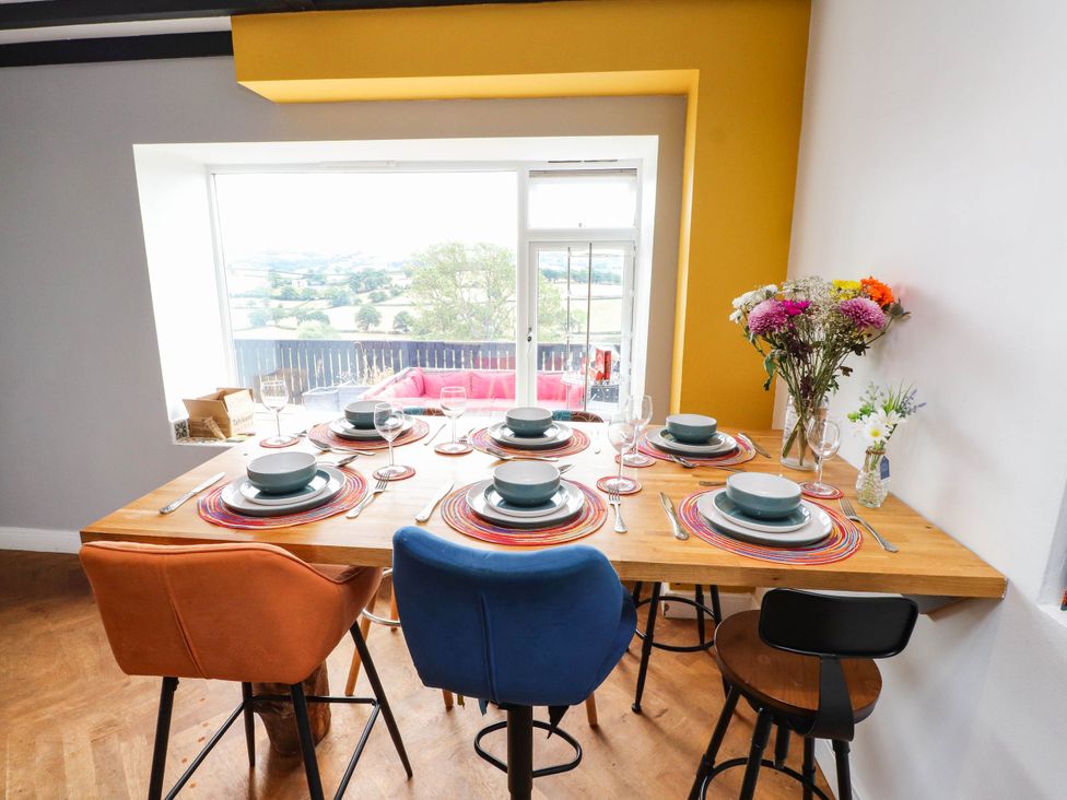A dining room with a table set at Tyddyn Elidir near Old Colwyn