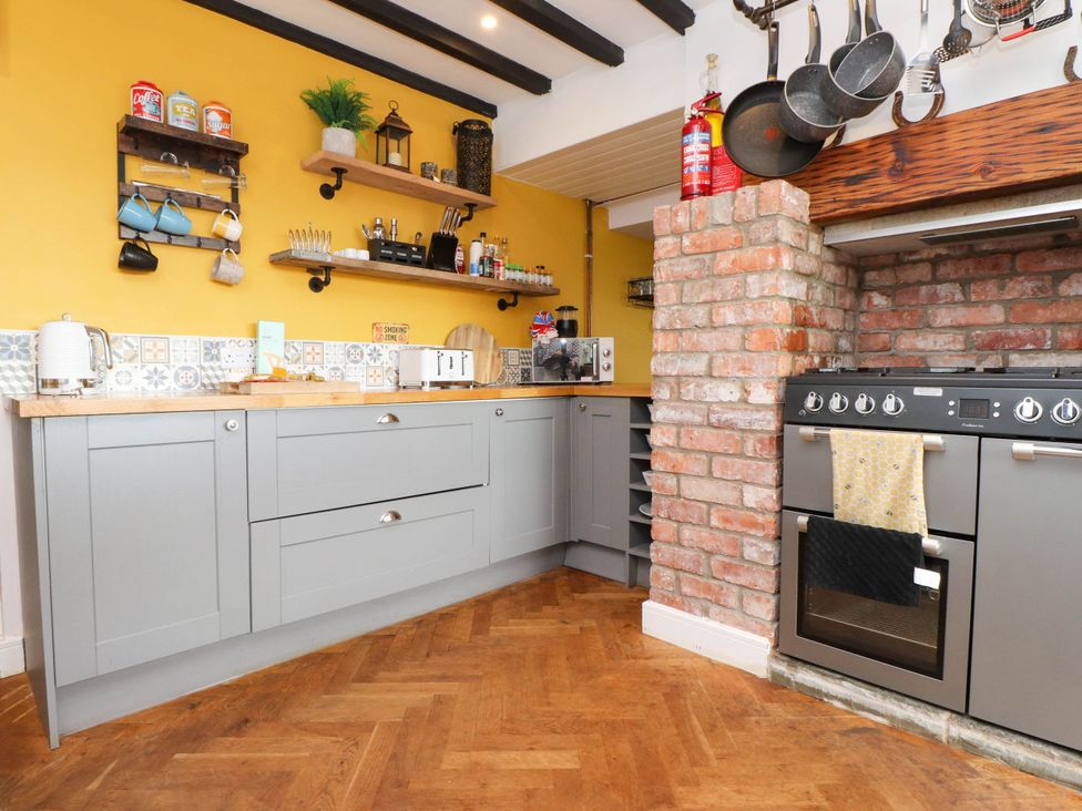 A kitchen with cabinets, a stove, and shelves at Tyddyn Elidir near Old Colwyn