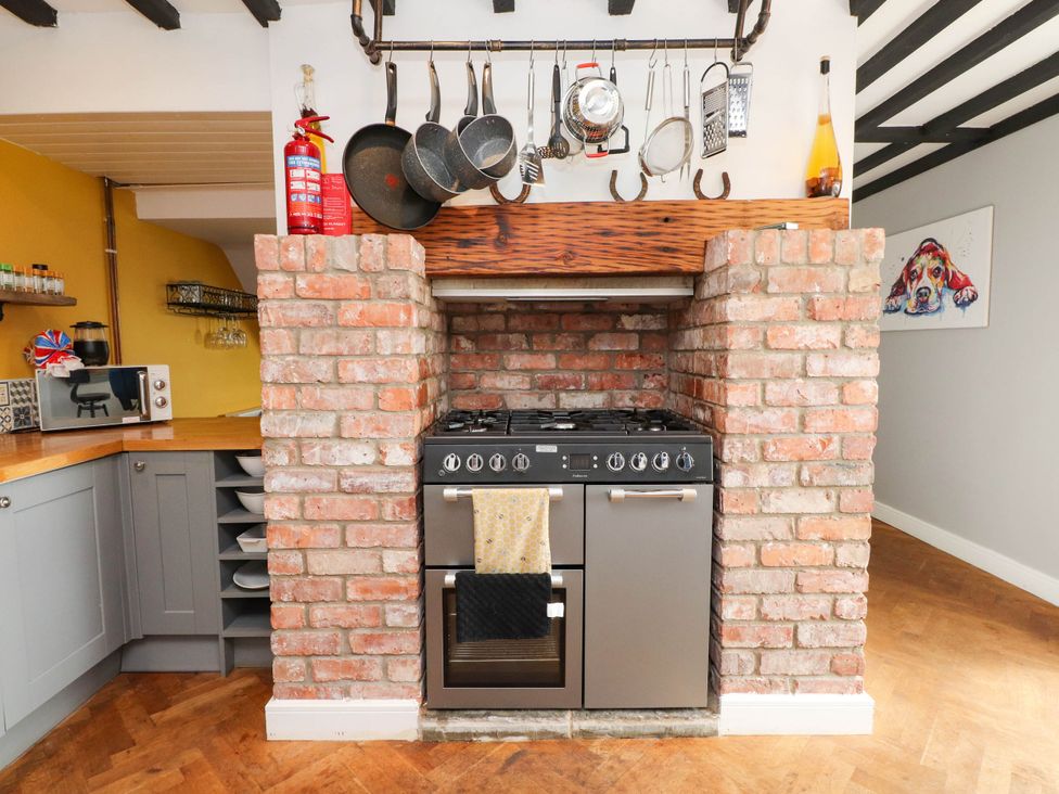 A kitchen with a stove and brick wall at Tyddyn Elidir near Old Colwyn