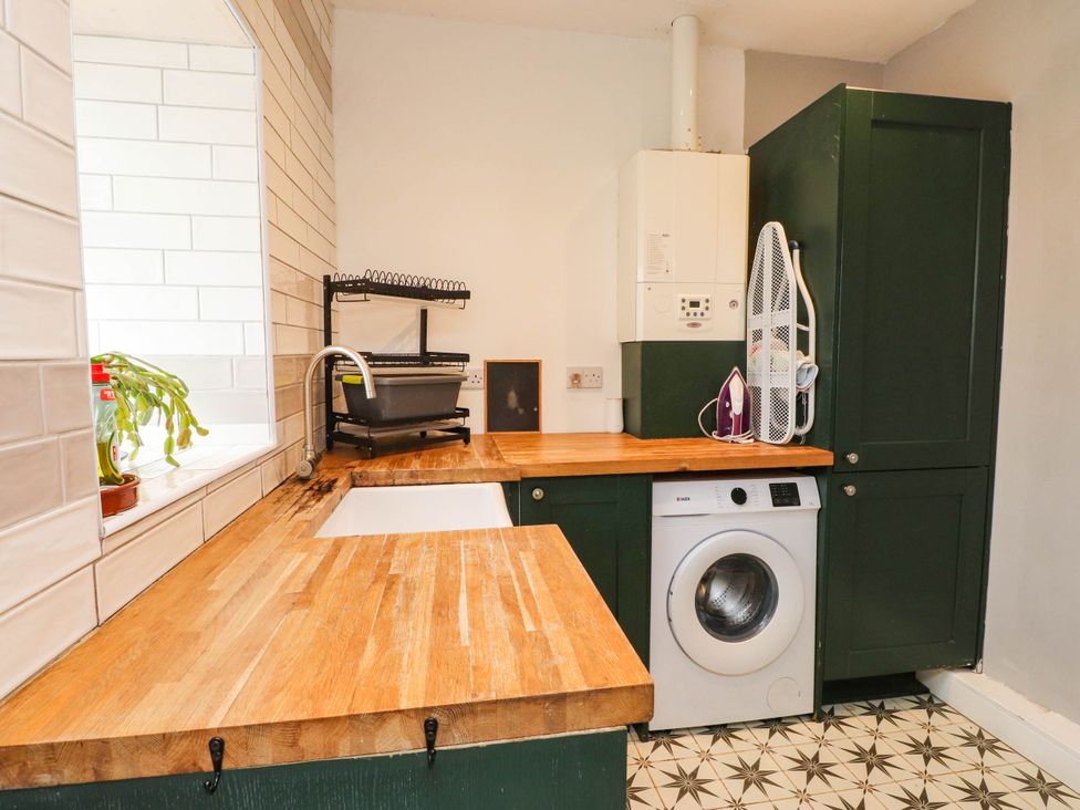 A kitchen with a washing machine and sink at Tyddyn Elidir near Old Colwyn