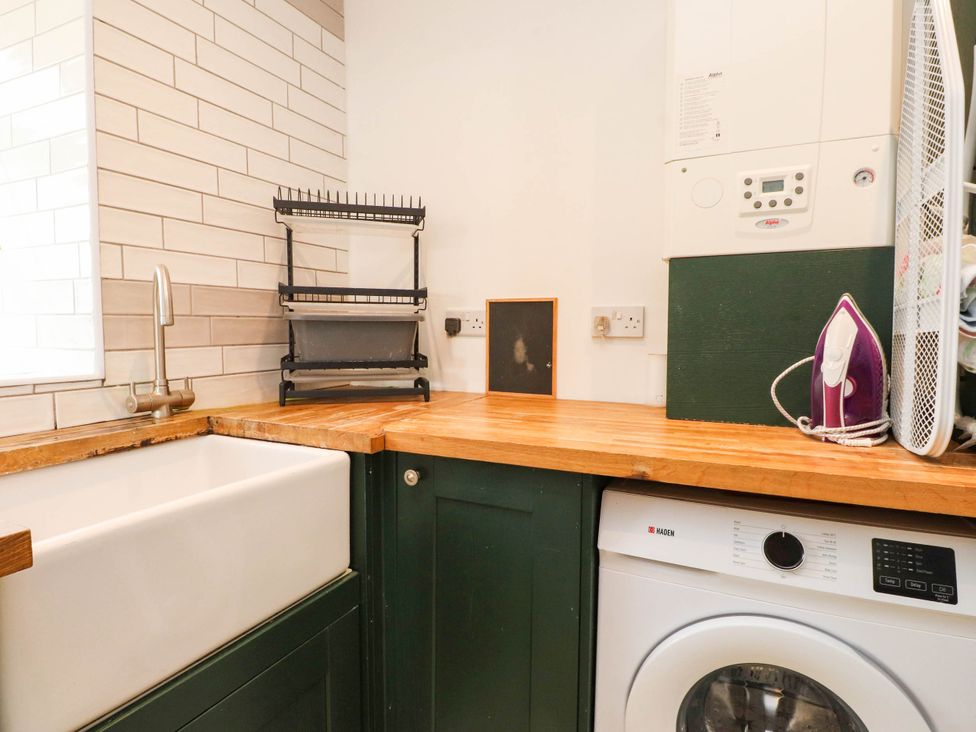 A laundry room with a sink and washing machine at Tyddyn Elidir near Old Colwyn