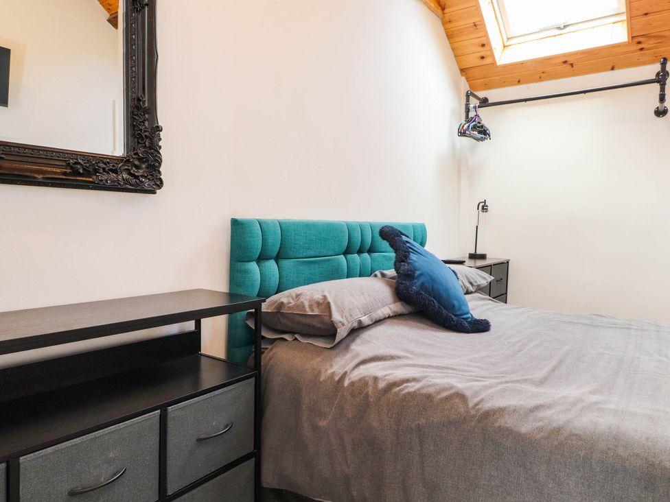A bedroom with a bed and nightstand at Tyddyn Elidir near Old Colwyn