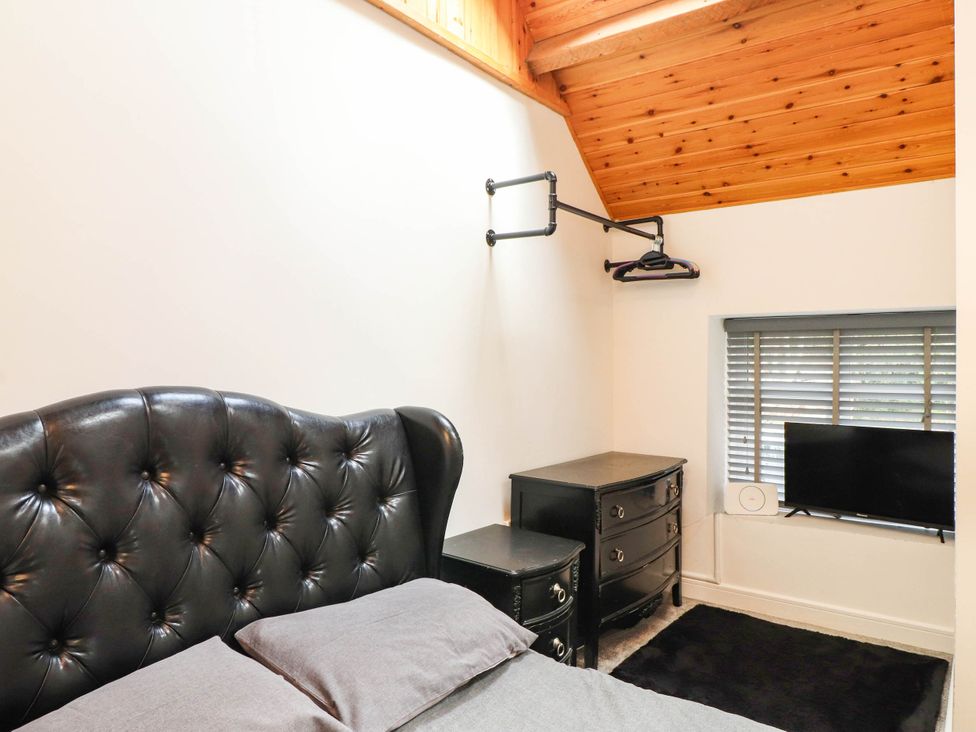A bedroom with a bed and dresser at Tyddyn Elidir near Old Colwyn