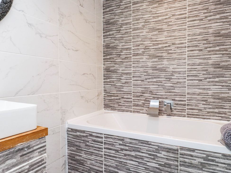 A bathroom with a bathtub and sink at Tyddyn Elidir near Old Colwyn