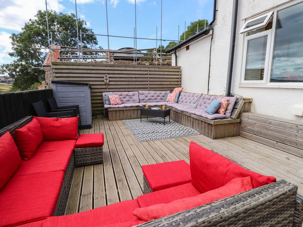 An outdoor seating area with sectional sofa and coffee table at Tyddyn Elidir near Old Colwyn