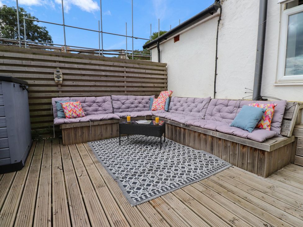 An outdoor seating area with cushions and a coffee table at Tyddyn Elidir near Old Colwyn