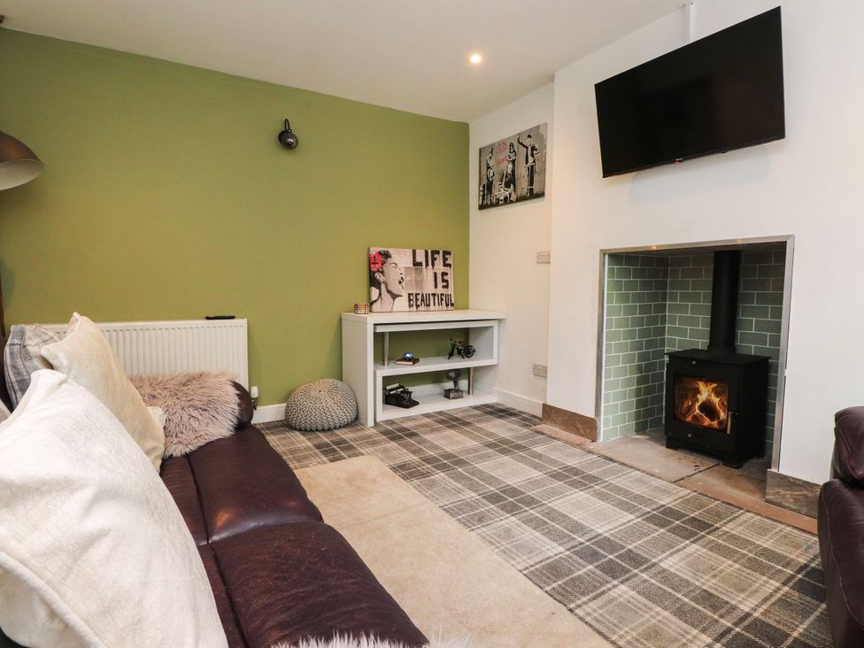 A living room with a sofa and a fireplace at Tyddyn Elidir near Old Colwyn