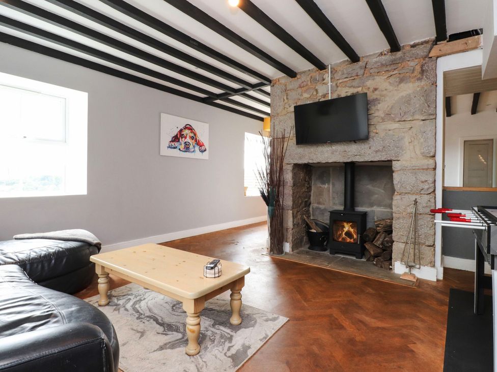 A living room with a sofa, coffee table, television and fireplace at Tyddyn Elidir near Old Colwyn