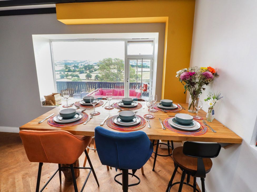 A dining room with a table set for dinner at Tyddyn Elidir near Old Colwyn