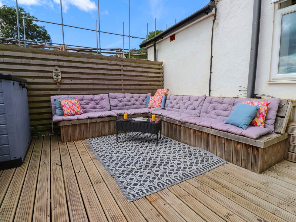 An outdoor seating area with cushioned seating and a coffee table at Tyddyn Elidir near Old Colwyn