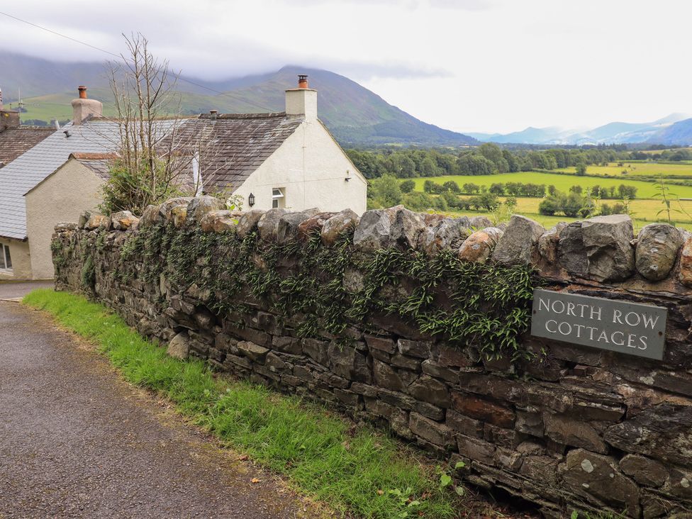 An outdoor view of North Row Cottages and stone wall in Bassenthwaite