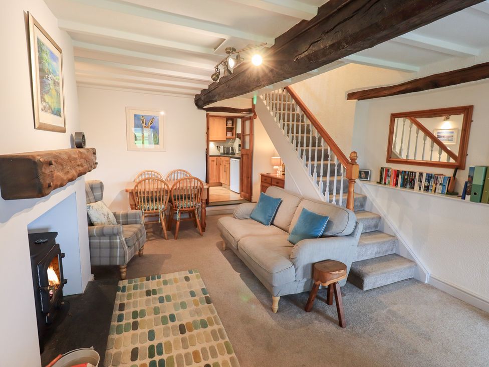 A living room with a sofa and dining area at Squirrel Cottage in Bassenthwaite