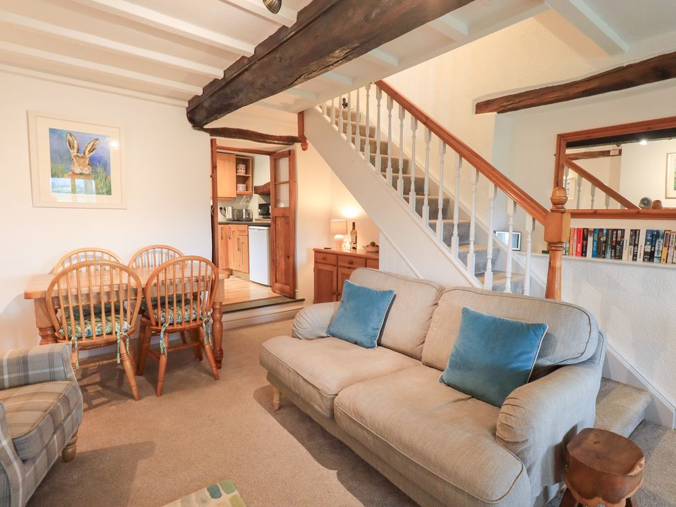 A living room with a sofa and dining table at Squirrel Cottage in Bassenthwaite
