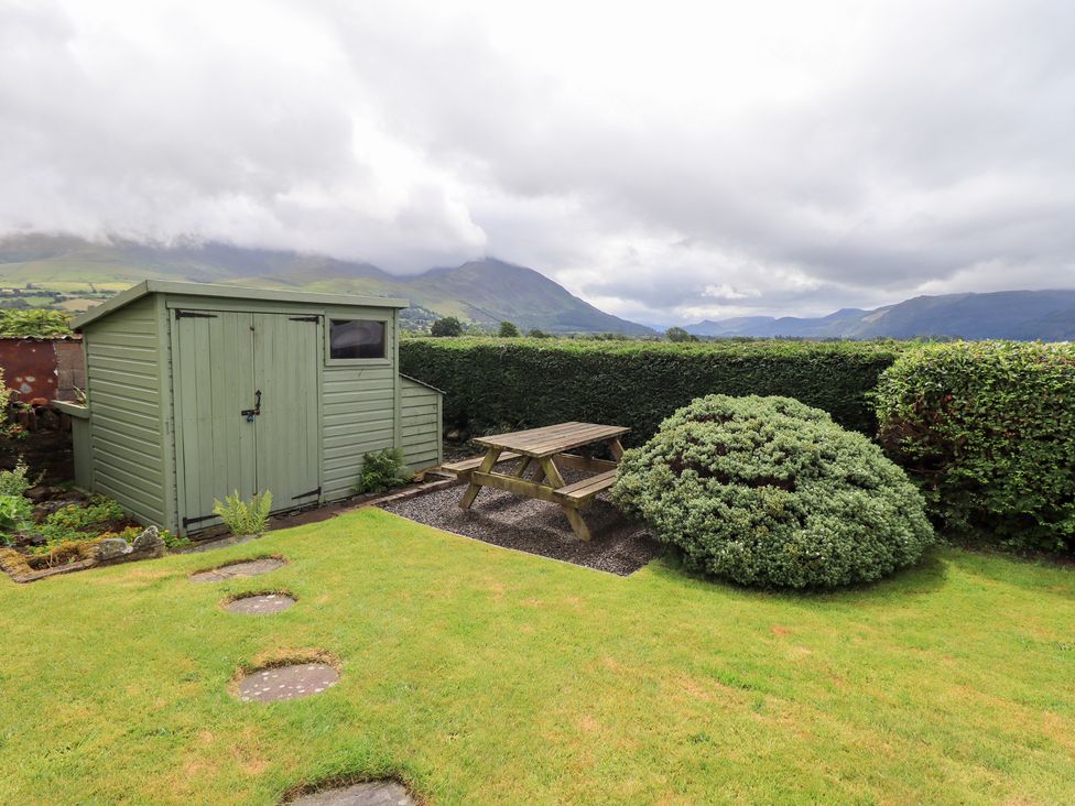 A garden with a shed and picnic table at Squirrel Cottage in Bassenthwaite