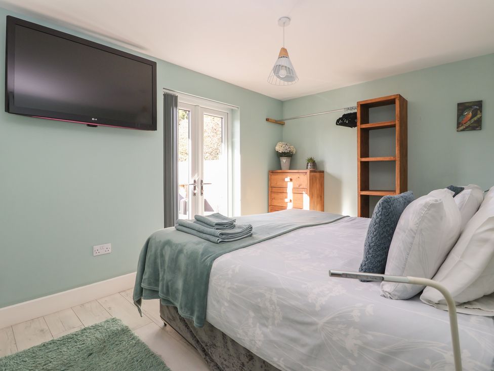 A bedroom with a bed and television at Meadowbank Lodge in Brandesburton