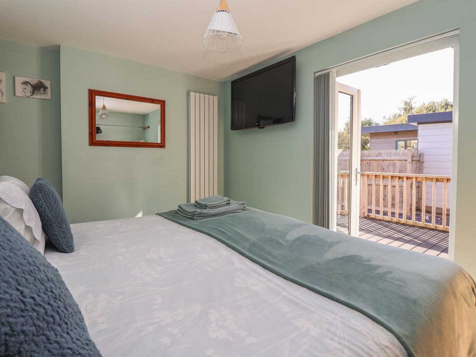 A bedroom with a bed and television at Meadowbank Lodge in Brandesburton