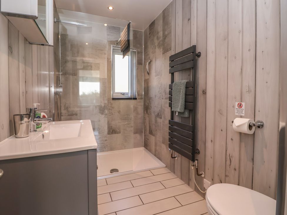 A bathroom with a shower, sink, and toilet at Meadowbank Lodge in Brandesburton