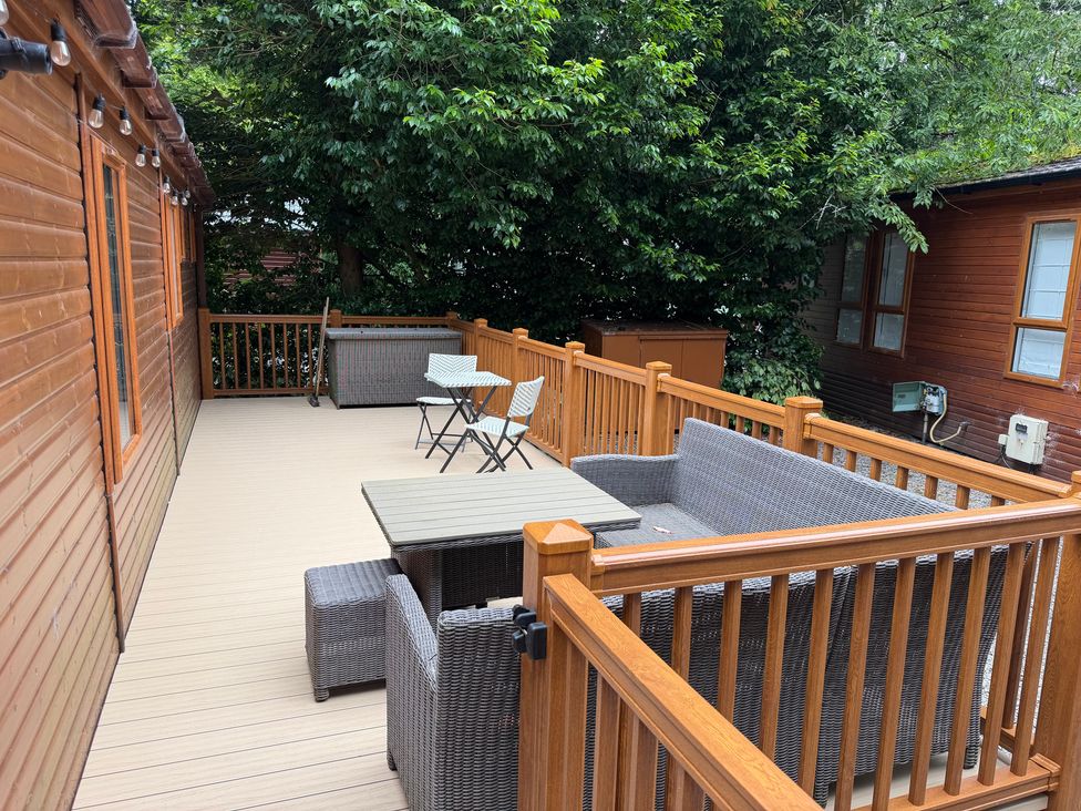 An outdoor seating area with a table and chairs at Cherry Tree Lodge, Calgarth 37, White Cross Bay near Windermere