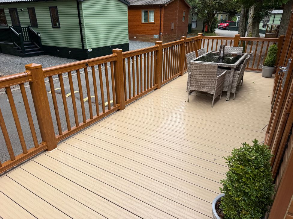 An outdoor deck with a table and chairs at Cherry Tree Lodge, Calgarth 37, White Cross Bay near Windermere