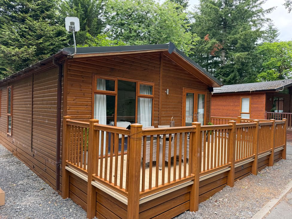 A wooden lodge with a deck and railing at Cherry Tree Lodge Calgarth 37, White Cross Bay near Windermere