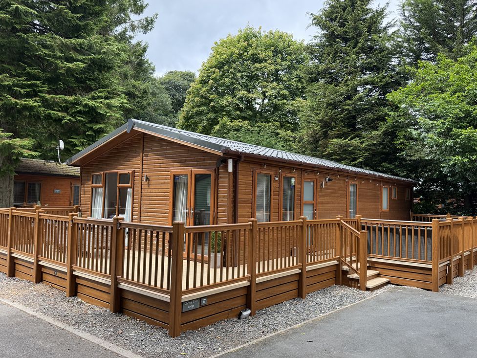 A wooden lodge with decking at Cherry Tree Lodge, Calgarth 37, White Cross Bay near Windermere
