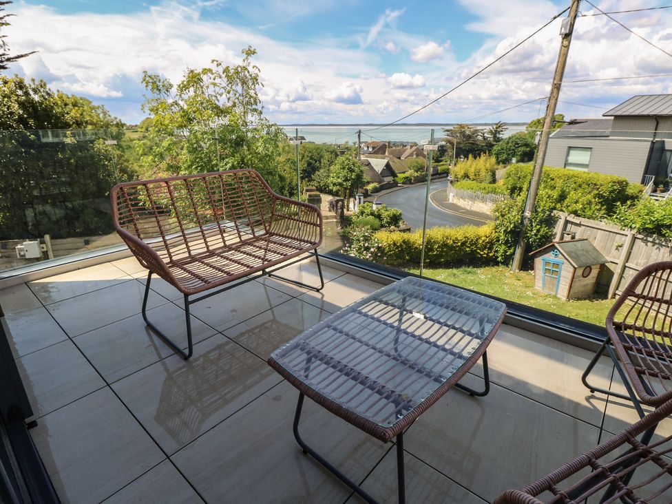 An outdoor seating area with a glass table and seating at Aquanaut in Gurnard