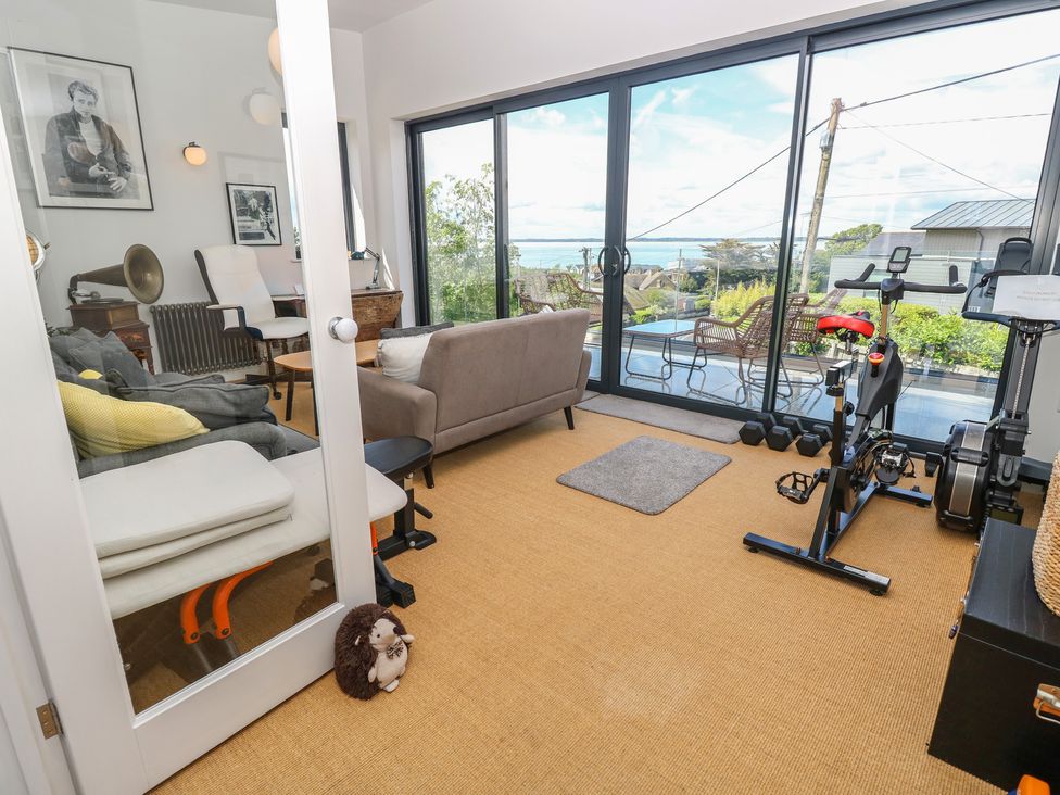 A living room with an exercise bike and a sofa at Aquanaut in Gurnard