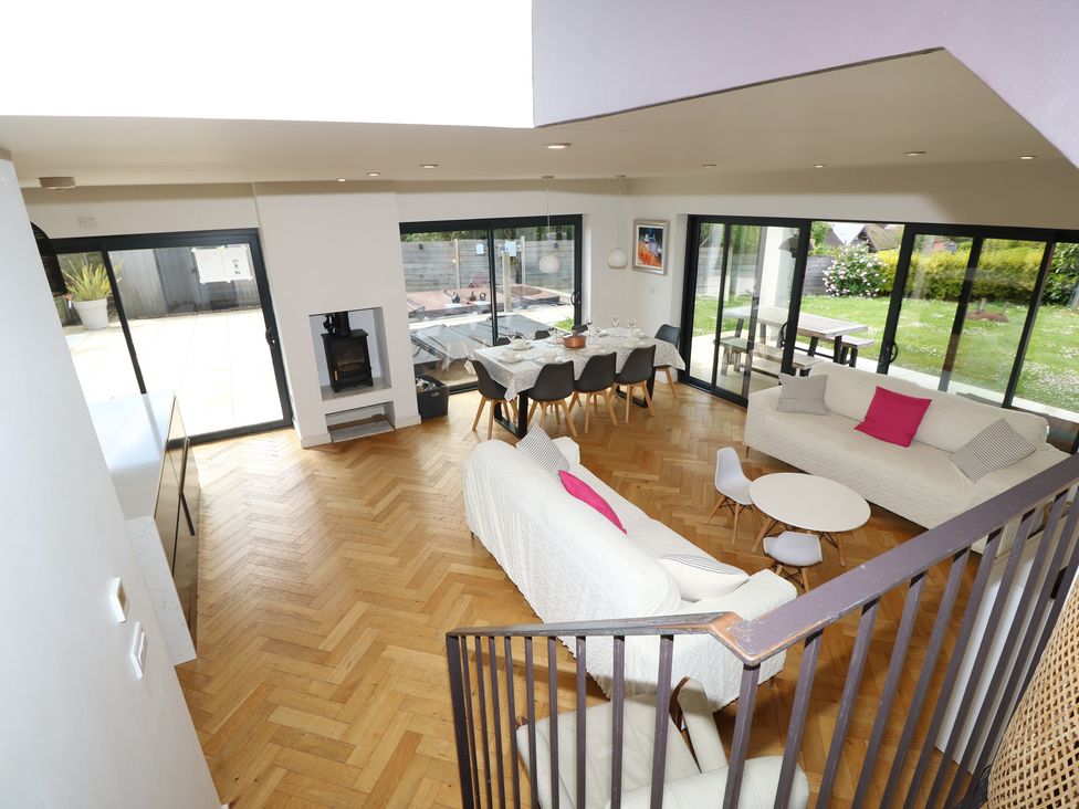 A living room with a dining area and glass doors at Aquanaut in Gurnard