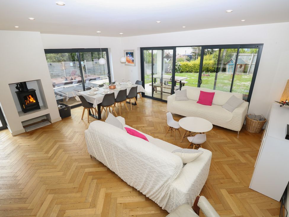 A living room with a fireplace and dining area at Aquanaut in Gurnard