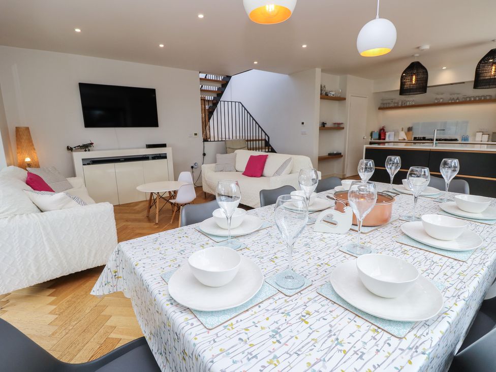 A living room with a dining table set for meals at Aquanaut in Gurnard
