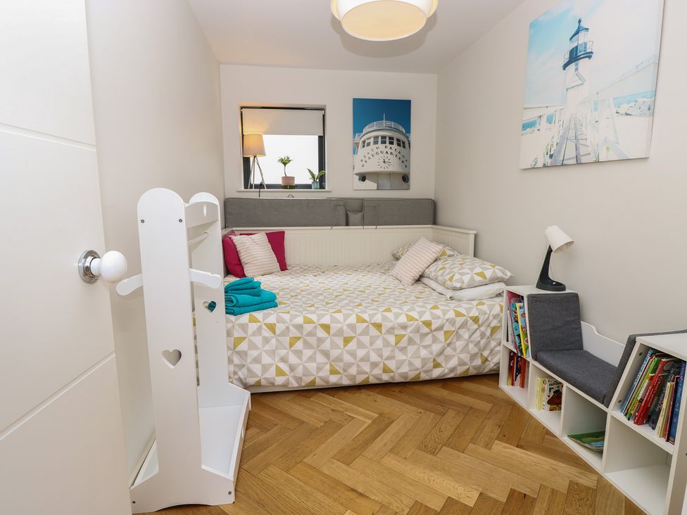 A bedroom with a bed and bookshelf at Aquanaut in Gurnard