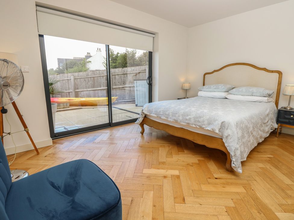 A bedroom with a bed and sliding doors at Aquanaut in Gurnard