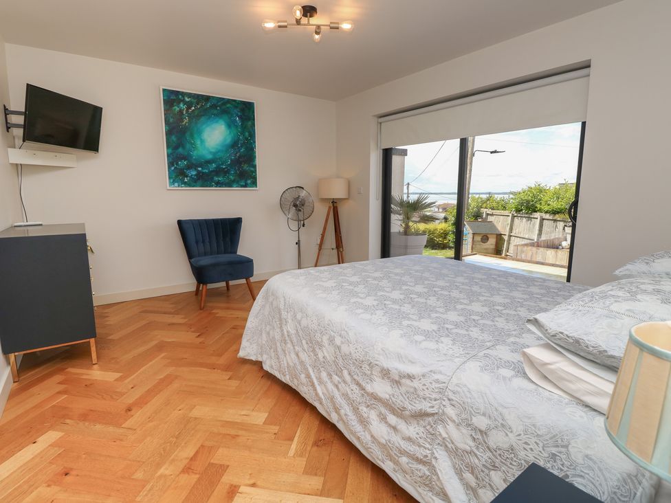 A bedroom with a bed and armchair at Aquanaut in Gurnard