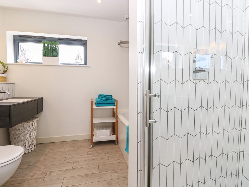 A bathroom with a shower and washbasin at Aquanaut in Gurnard