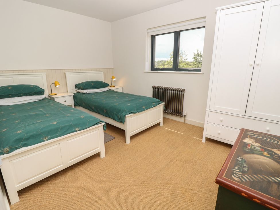 A bedroom with two single beds and a wardrobe at Aquanaut in Gurnard