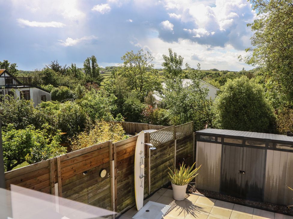 A garden view featuring a shed and a surfboard at Aquanaut in Gurnard