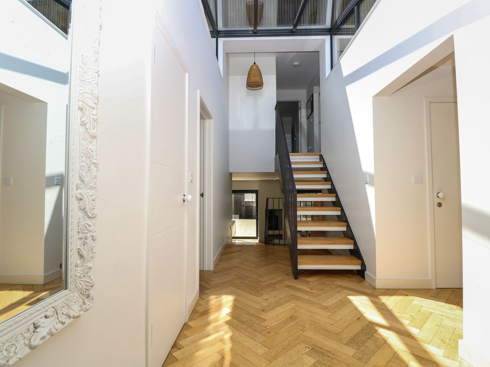 A hallway with stairs and a mirror at Aquanaut in Gurnard