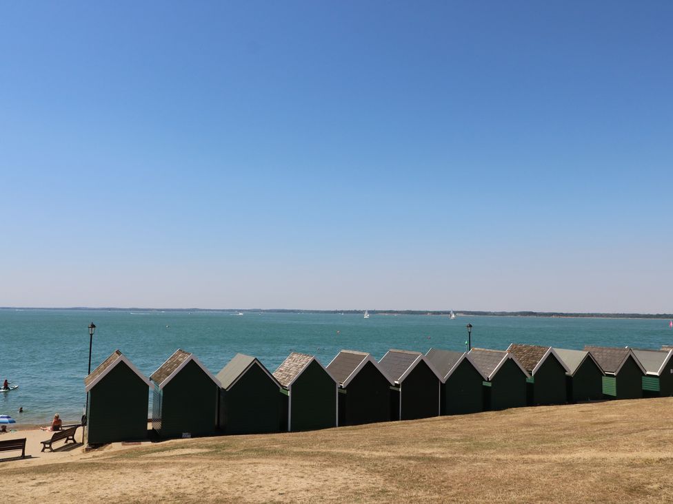 Beach huts along the coast with ocean and boats at Aquanaut Gurnard