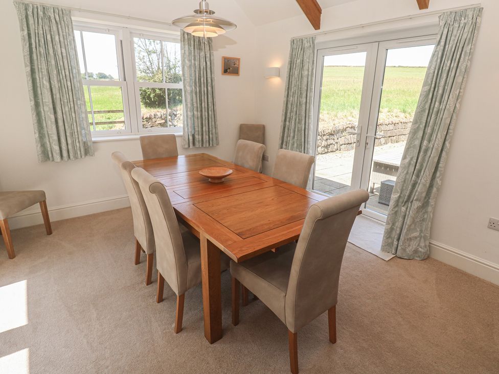 A dining room with a wooden table and chairs at Ilgram in St Newlyn East