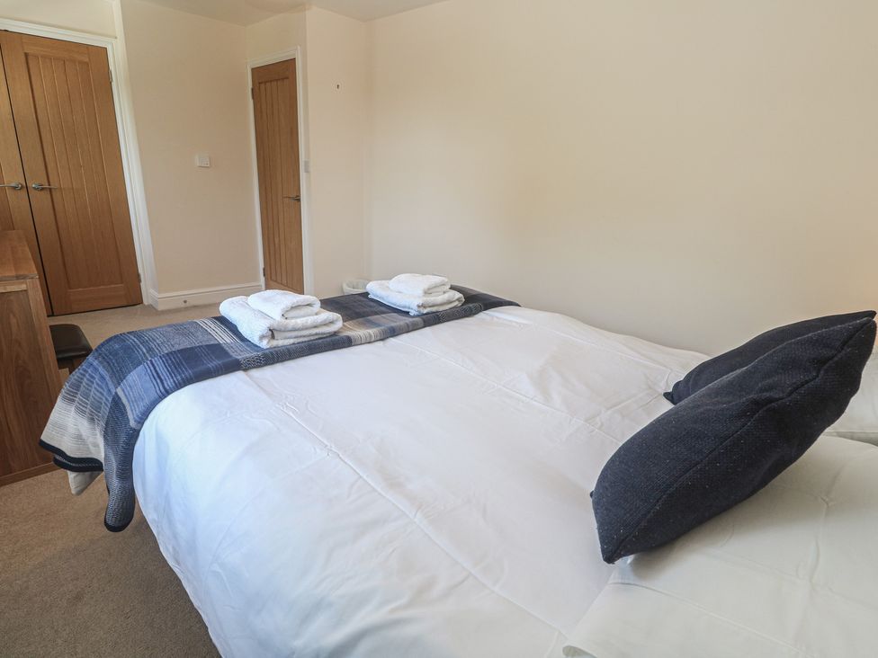 A bedroom with a bed and towels arranged at Ilgram in St Newlyn East