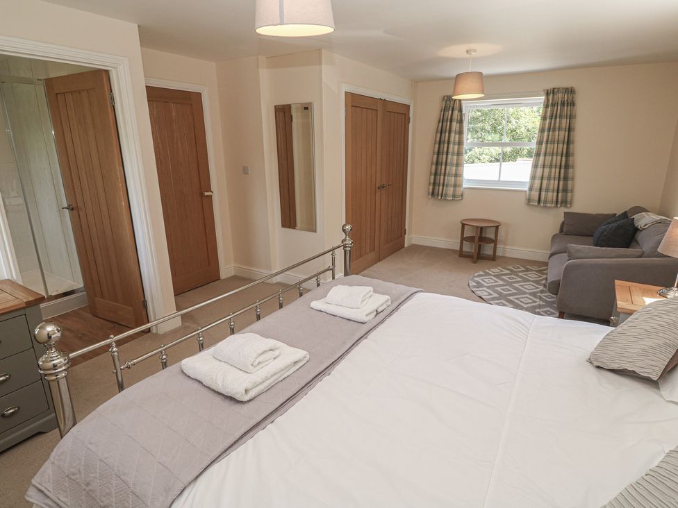 A bedroom with a bed and sofa at Ilgram in St Newlyn East