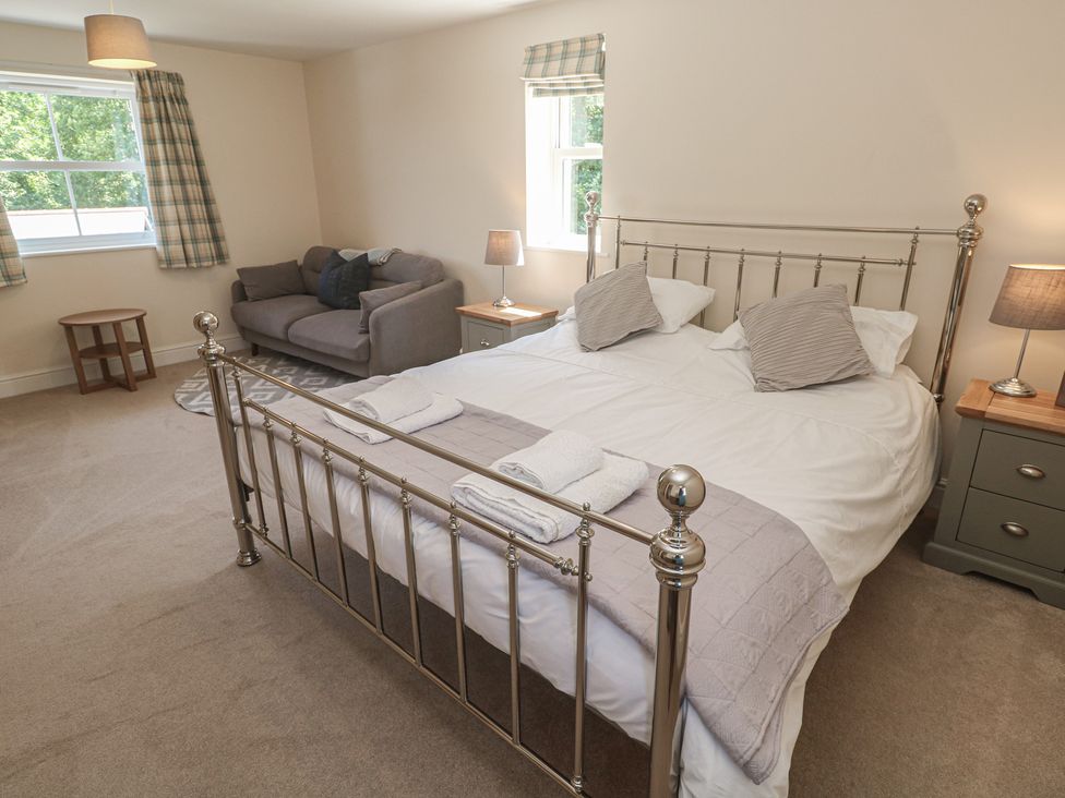 A bedroom with a bed and a sofa at Ilgram in St Newlyn East