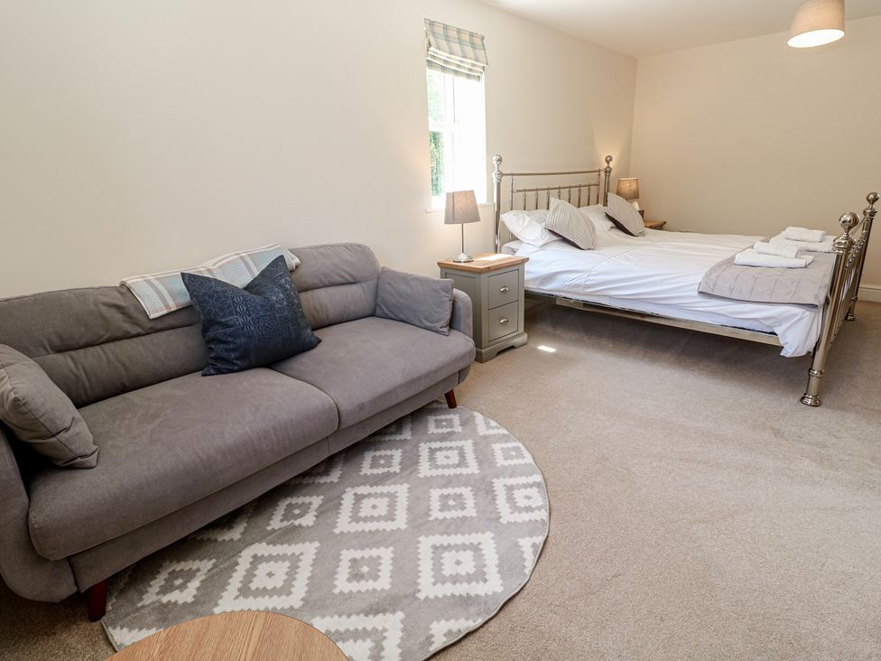 A bedroom with a bed and sofa at Ilgram in St Newlyn East