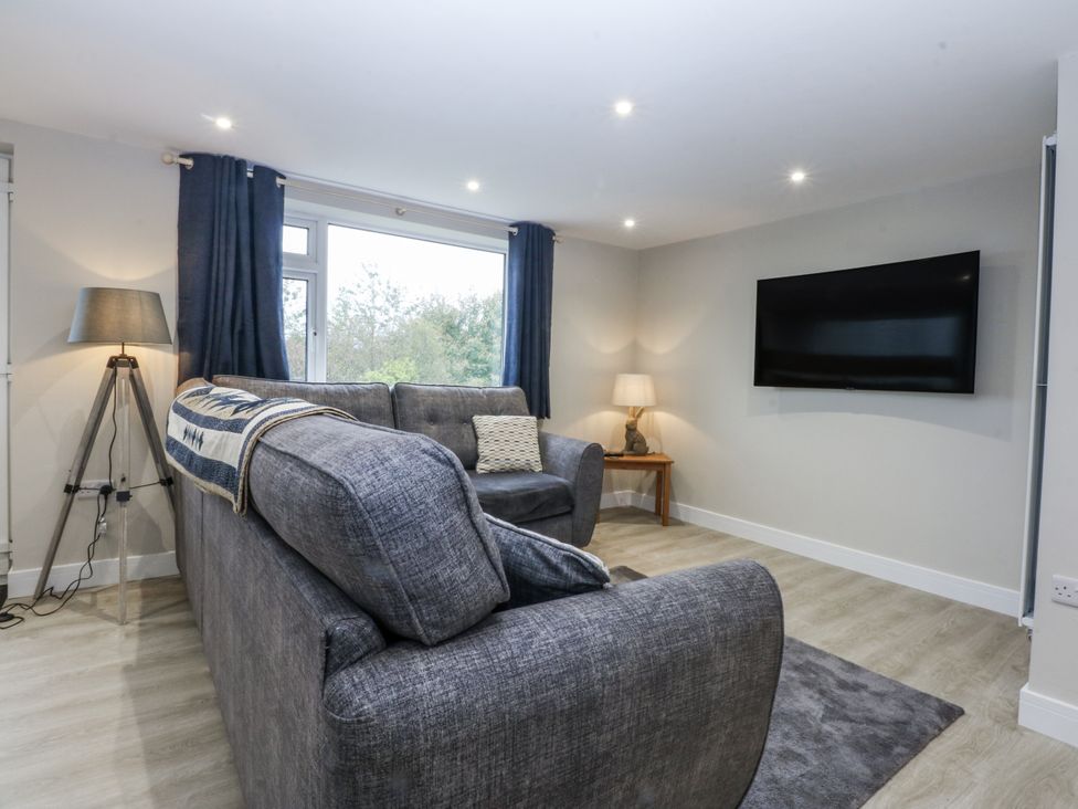 A living room with a sofa and television at Caledfryn Tyn-y-Gongl