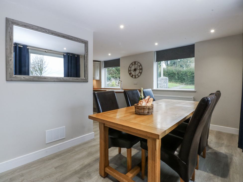 A dining room with a table and chairs at Caledfryn in Tyn-y-Gongl