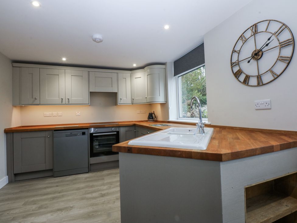 A kitchen with cabinets and appliances at Caledfryn in Tyn-y-Gongl