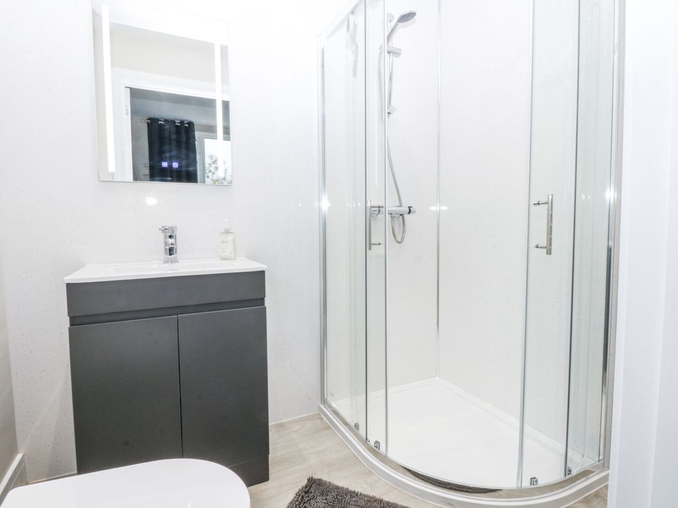 A bathroom with a shower and sink at Caledfryn in Benllech