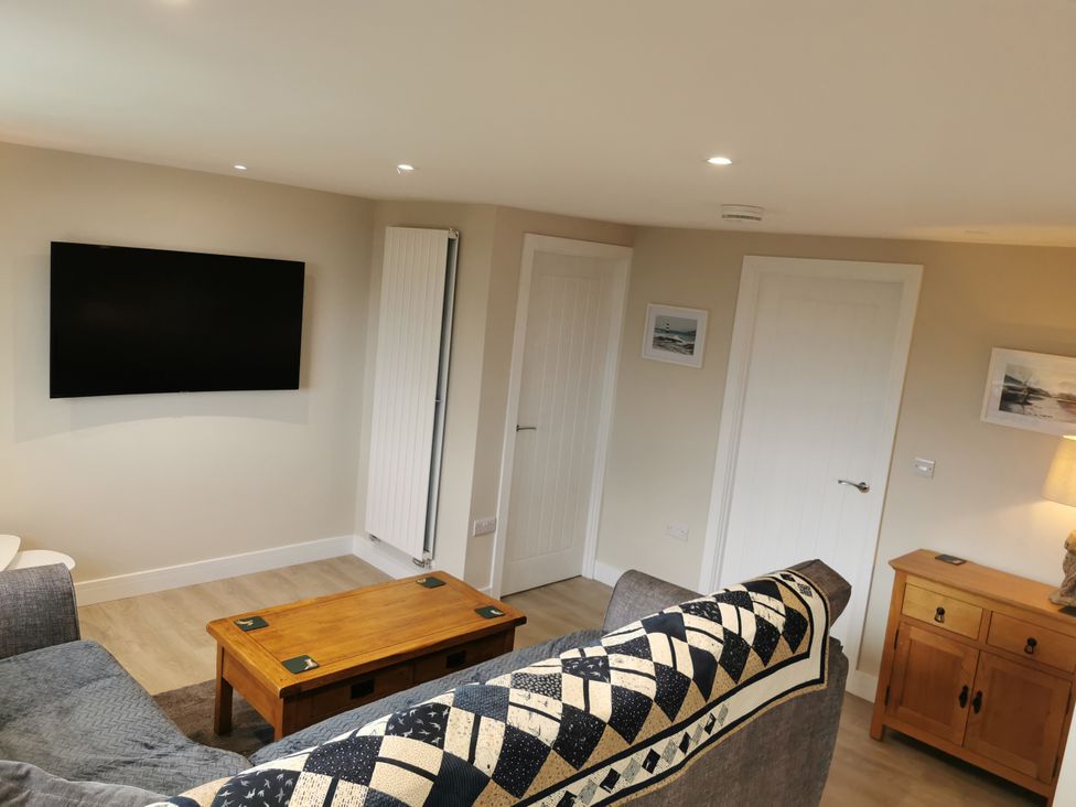 A living room with a television and coffee table at Caledfryn in Benllech
